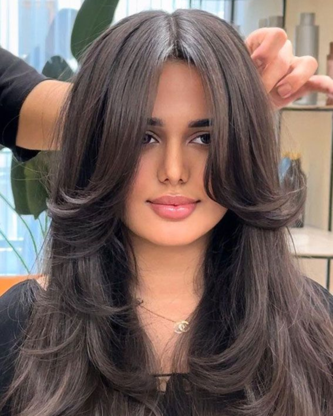 Professional stylist giving a trendy layer cut to a smiling client – Haircuts for Women Near Me